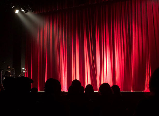 Presenters & Hosts on a stage with a curtain