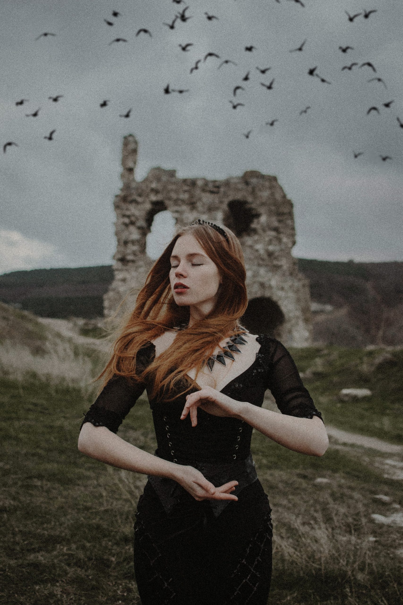 woman posing with a castle and birds in the background