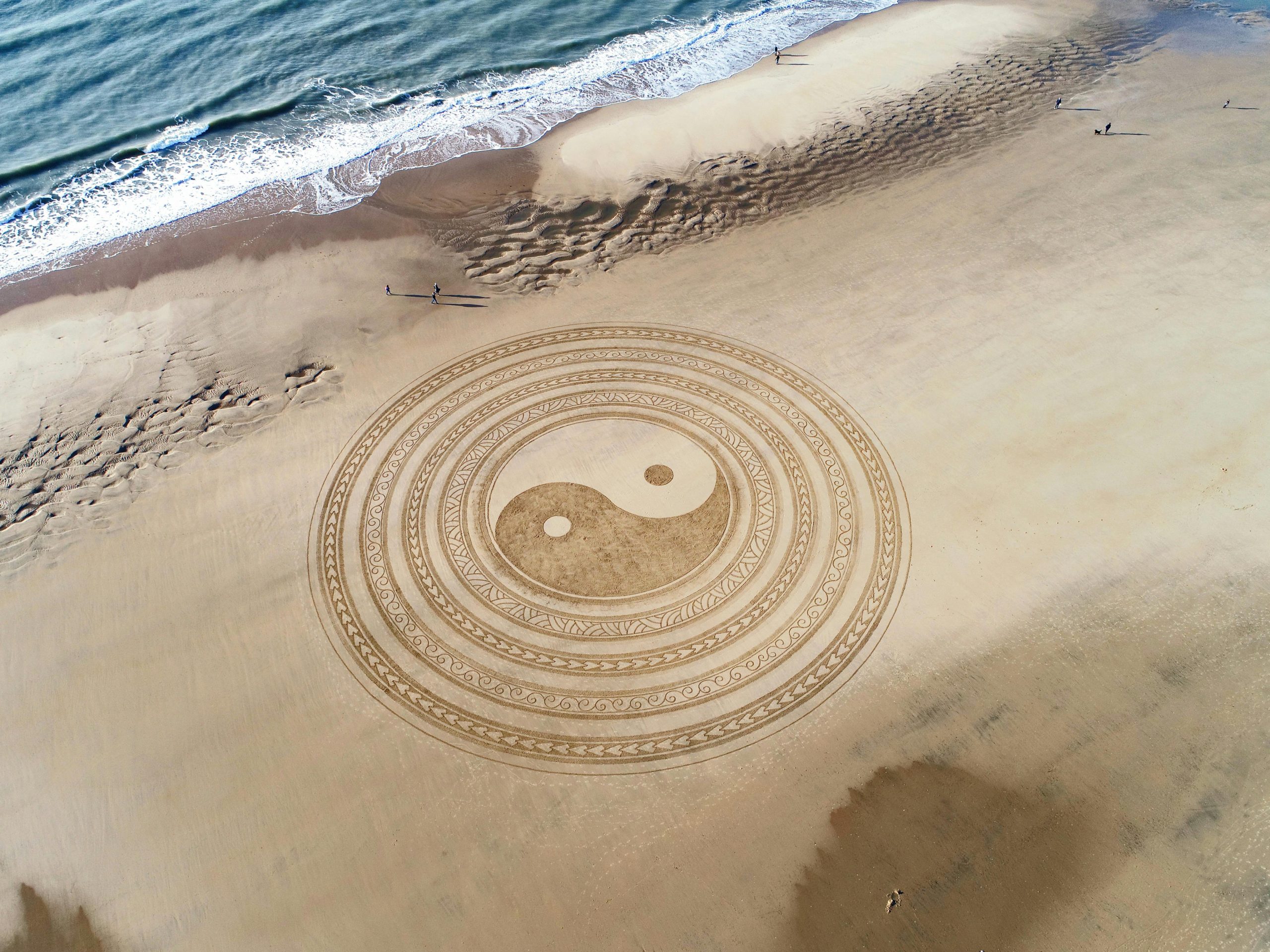 ying and yang drawn in the sand